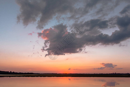 日落倒影泻湖在云层和蓝天之上的泻湖景观背景之上的美丽日落日落时有云图片