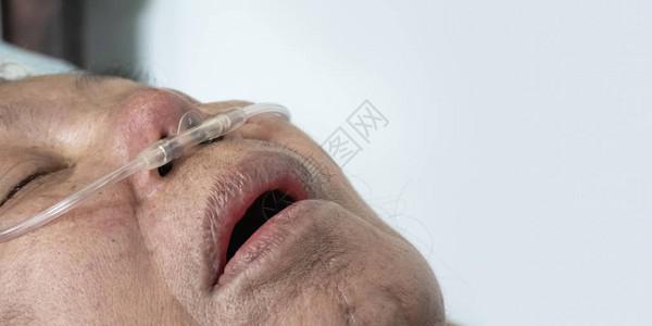 拥有鼻喉呼吸管帮助家中呼吸的年长妇女背景图片