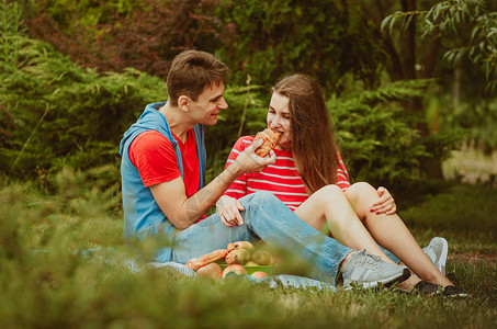 相爱的美丽年轻夫妇决定在公园里进行浪漫野餐约会共度时光是无价之宝在农村露营周末想法图片