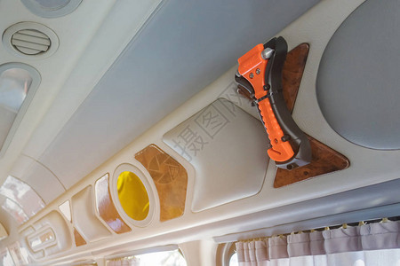橙色安全玻璃锤子安装在窗玻璃和面包车窗帘上图片