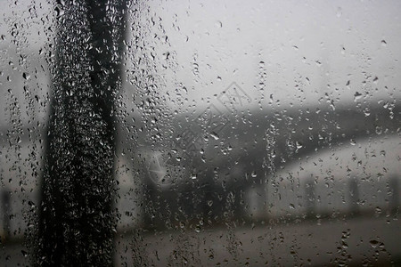 在大雨中驾驶汽车在桥下道路交通灯光过桥通过车窗查看雨滴落在车窗上图片
