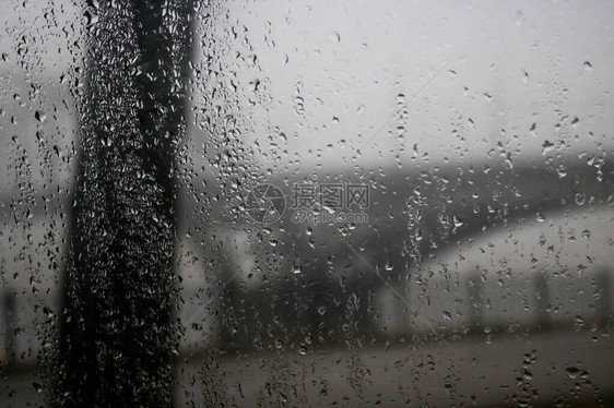 在大雨中驾驶汽车在桥下道路交通灯光过桥通过车窗查看雨滴落在车窗上图片