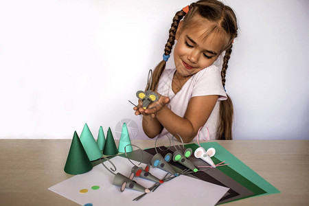 岁女孩用彩色纸和装饰打孔器制作手工老鼠图片