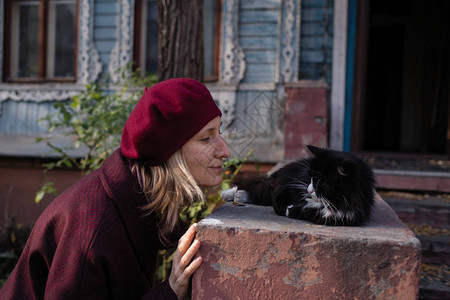 一个女人和一只猫玩贝雷帽在老古董乡村图片
