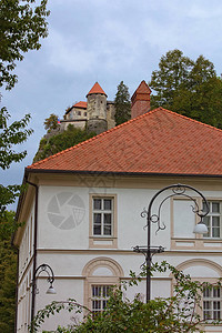 红瓦屋顶的大两层住宅楼背景中悬崖上著名的布莱德城堡欧洲著名的旅游胜地图片