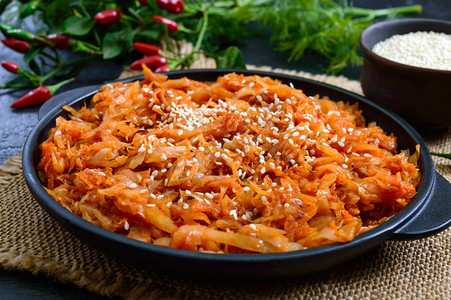 在黑色背景的铸铁煎锅中用番茄酱炖白菜四旬期菜单饮食图片