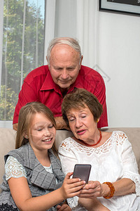祖父母与孙子共度时光的镜头一个年轻的女孩向她的祖父和祖母展示她的图片