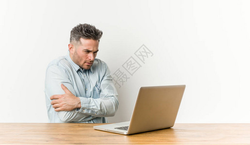 英俊的年轻人在笔记本电脑上工作因为低温图片