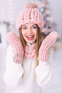 穿着粉红色帽子围巾和手套的女孩的肖像微笑和美丽的化妆图片