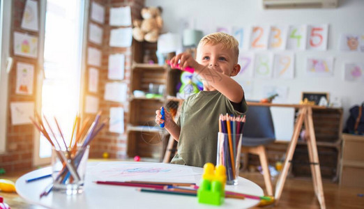 幼稚的天主教儿童在幼儿园用彩色铅笔绘画图片