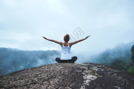 年轻女子在山上练习瑜伽亚洲女人旅行的质旅行放松练习瑜伽触摸山图片