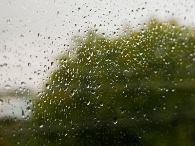 玻璃上的雨滴阴雨天气在自然模糊的背景下秋日窗上的雨滴图片