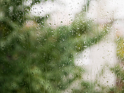 玻璃上的雨滴阴雨天气在自然模糊的背景下秋日窗上的雨滴背景图片
