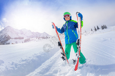 快乐的小男孩站在山顶高山滑雪中在斜坡上新鲜的图片