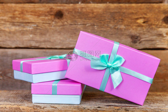 礼品盒用丝带包裹着粉红色的纸小圣诞或装饰旧破仿古木制背景上的礼物圣诞节生日情人节庆祝图片