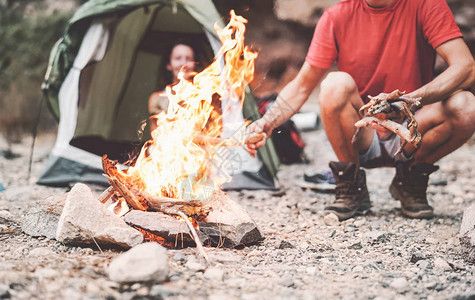 快乐的情侣在野林露营时生火图片