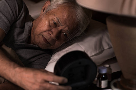 躺在床上的压抑的老年人睡不着失背景图片