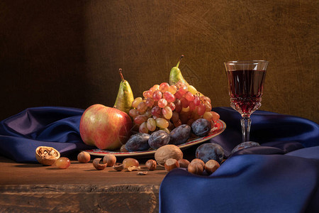 葡萄苹果梨李子坚果和蓝色窗帘图片
