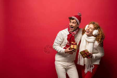 穿着圣诞礼物的美丽的情侣在冬天穿衣盛装背景图片