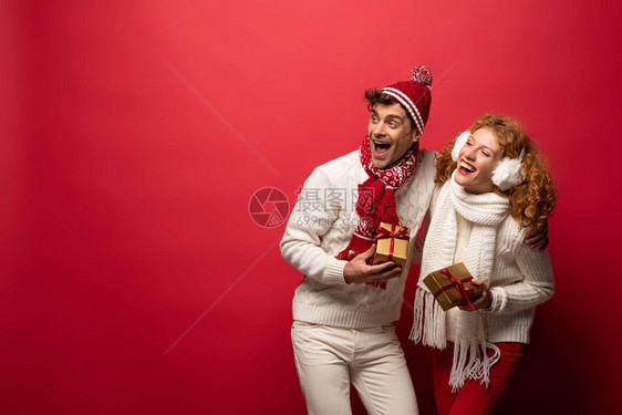 穿着圣诞礼物的美丽的情侣在冬天穿衣盛装图片