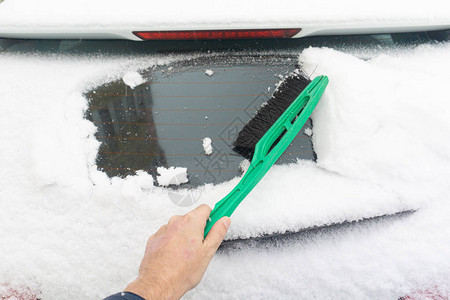 由雪覆盖的车挡风玻璃在冬季下雪时被雪遮盖的停泊图片