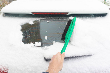 由雪覆盖的车挡风玻璃在冬季下雪时被雪遮盖的停泊图片