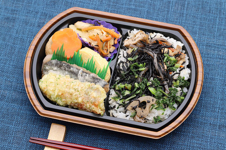 用筷子在餐桌上的日式便当午餐图片