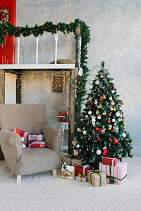 客厅或餐厅的传统经典圣诞树和米色扶手椅图片