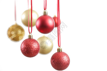 在白色背景面前挂着金色和红色的圣诞闪亮球图片