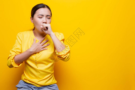 女人在黄色背景下有喉咙痛图片