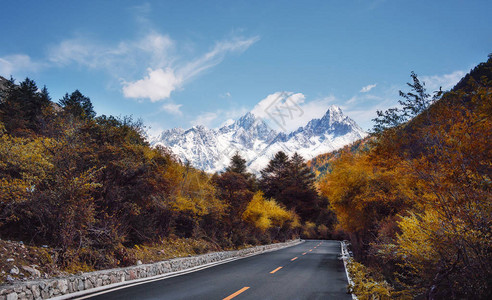 木格措四川秋季和雪山风雪中乡村公路背景