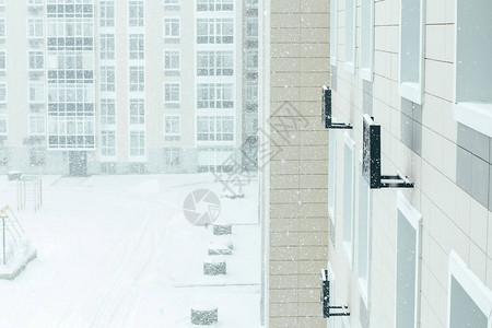 城市暴风雪住宅楼的院子被雪覆盖图片