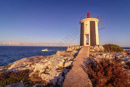 灯塔在有船海和浪的岩石上背景图片