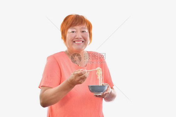 女人用筷子吃东西看着镜头笑着微笑白色背景商业图片