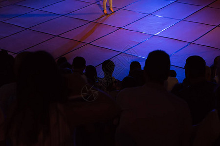 以探照灯的亮光观看音乐会的Silhouettes一群人图片