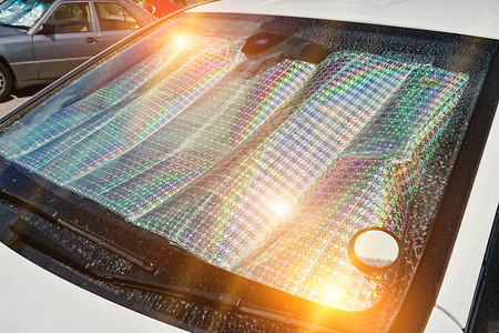 汽车挡风玻璃与防护反射防晒霜表面在停街道上的汽车内图片