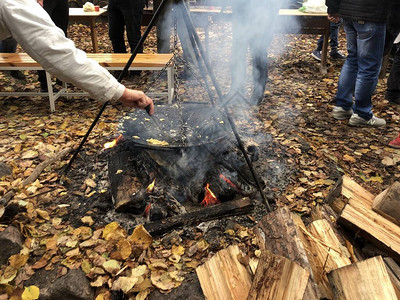 在火炉旁和一家公司野餐烧着鸡蛋煮煎蛋卷在森图片