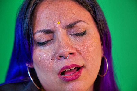 拉丁女人唱着吉他在紫色背景上唱歌用流下蓝色图片