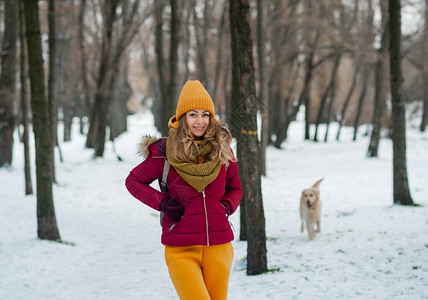 年轻美丽的黑发女人在雪地里穿着黄色围巾的冬季肖像下雪的冬季图片