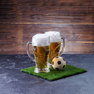 两杯啤酒足球在桌边图片