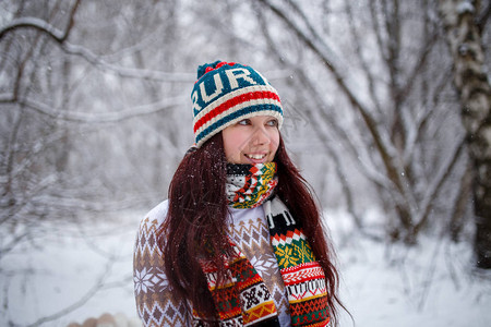 白天在冬季森林中用毛帽和围巾戴着微笑图片