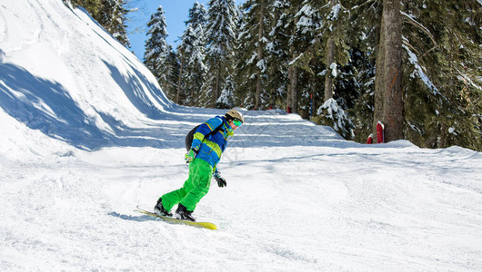 冬天一从雪山上骑滑雪板的人形象图片