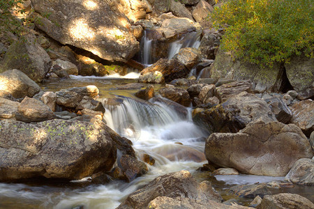 在山上流过花岗岩石的溪流图片