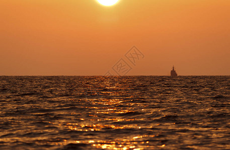 日落海滩背景海浪在傍晚日落的光线下太阳在地平线以下在海的地平线上图片