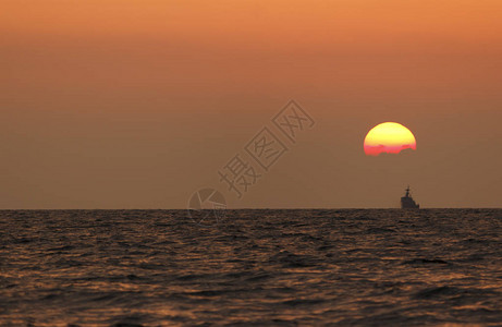 日落海滩背景海浪在傍晚日落的光线下太阳在地平线以下在海的地平线上图片