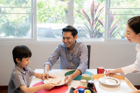 亚洲家庭父子在餐厅与母亲一起吃早餐幸图片