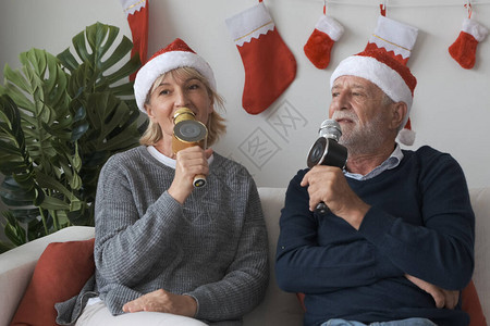高加索老年人和妇女高兴地在客厅里一起唱一首歌图片