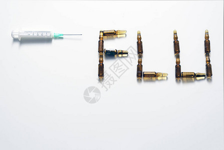 带有针头的注射器和用疫苗制成的流感词图片
