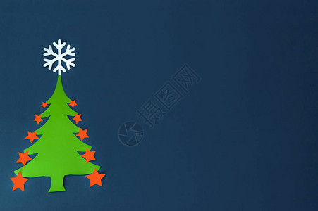 深蓝色背景中带雪花的纸绿色圣诞树图片