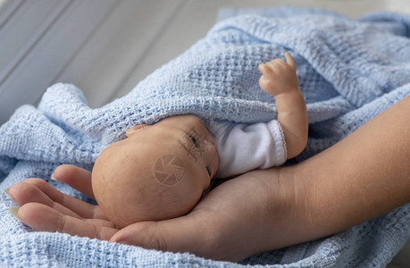 早产婴儿裹在蓝色毯子里图片